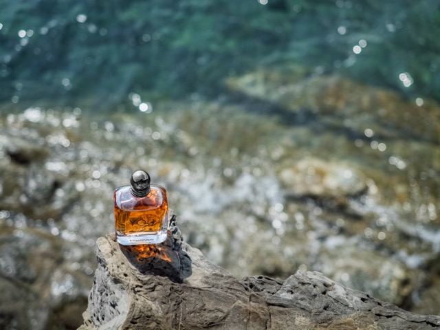 Profumo Armani Stronger With You in equilibrio su roccia con mare cristallino sullo sfondo - still life fragranze maschili