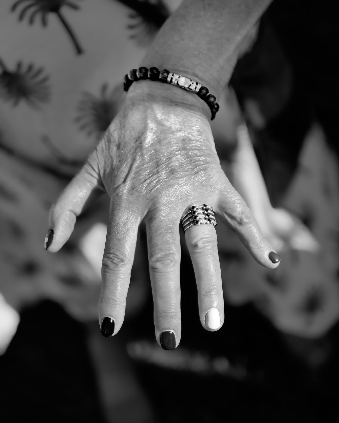Mano di un'invitata con anelli e bracciale, dettaglio in bianco e nero